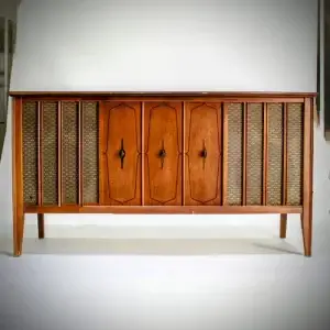 Mid-century modern wooden cabinet with three doors and woven panels.