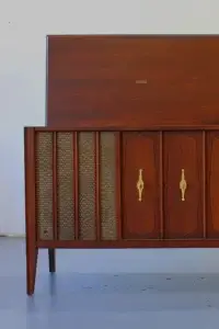 Eye-level front view of a restored Zenith mid-century modern stereo console with the left side lid propped open, showing the internal compartment and walnut finish.