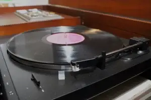 Close-up of a precision turntable spinning a record inside a restored mid-century modern Zenith audio console.