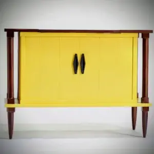 Yellow cabinet with wooden legs and handles.