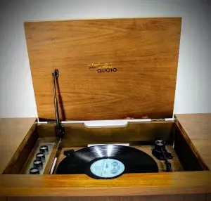 Wooden record player with a vinyl record playing.