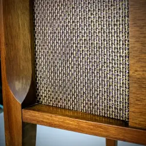 Close-up of a wooden cabinet with woven fabric detail.