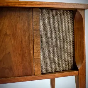 Wooden cabinet with woven panel on the front.