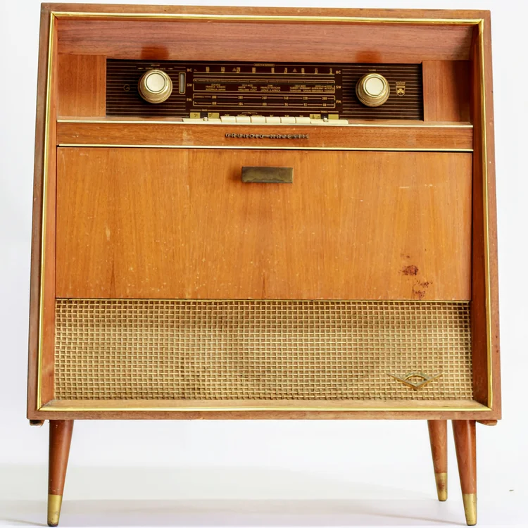 Vintage wooden radio console with a drawer and gold accents.