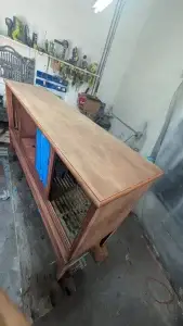 A mid-century Philco stereo console cabinet with the original finish completely removed, showing the raw light-colored wood grain before staining.
