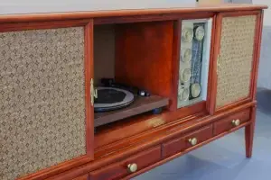 A refinished Philco mid-century modern stereo console with sliding front panels open to reveal a modern turntable and detailed vintage radio tuner.