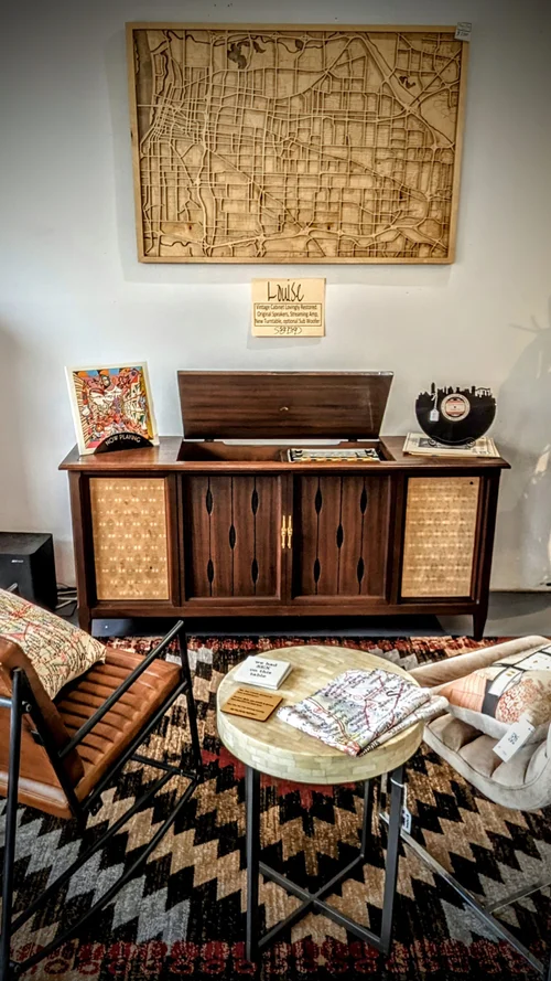 A mid-century modern living room with a wooden sideboard, chair, and coffee table.