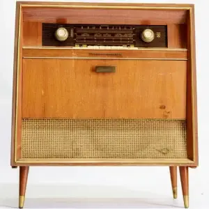 Vintage wooden radio with a cabinet door and tapered legs.