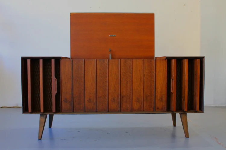 Mid-century modern wooden stereo console with speakers and record player.