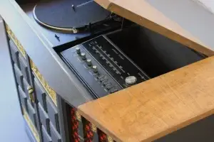 Top-down detail of a new Audio-Technica turntable integrated with original restored controls on a GE Multiplex console.