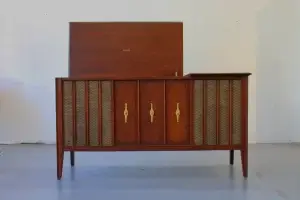Vintage wooden sideboard with woven panels and gold handles.