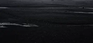 Puddles on a dark, rocky surface.