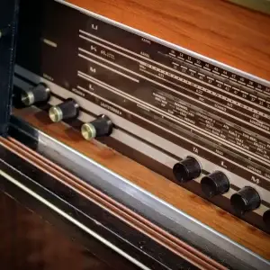 Vintage radio with wooden cabinet and multiple knobs and dials.