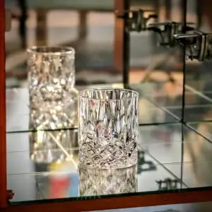 Crystal glasses on a glass shelf.