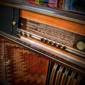 Vintage radio with wooden cabinet and multiple knobs and dials.