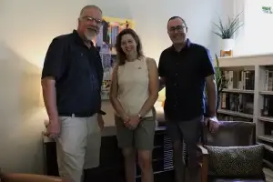 Satisfied clients standing together in a living room in front of their new Steiner Audio equipment.