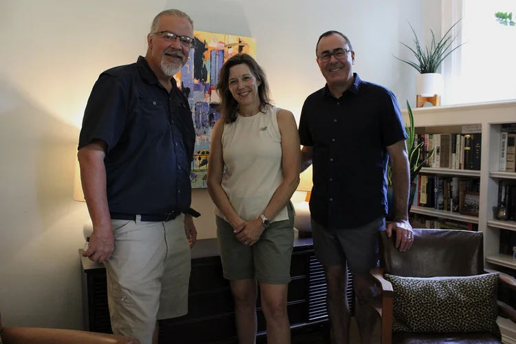 Satisfied clients standing together in a living room in front of their new Steiner Audio equipment.