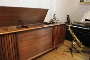 Wooden Steiner Audio cabinet with a saxophone and piano in the background.