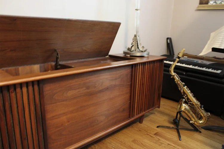 Wooden Steiner Audio cabinet with a saxophone and piano in the background.