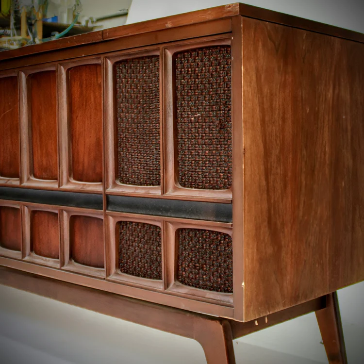 Vintage wooden stereo console with woven speaker grills.