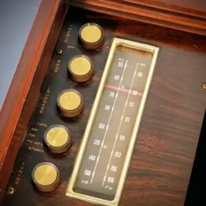 Close-up of the illuminated AM/FM tuner dial and gold control knobs on a restored Magnavox Brubeck.
