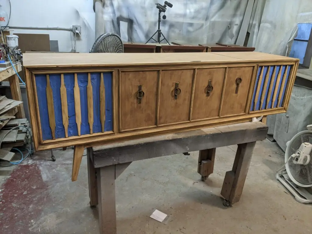 Hand-refinishing a walnut Zenith mid-century record player cabinet restored for a modernized vintage audio console.