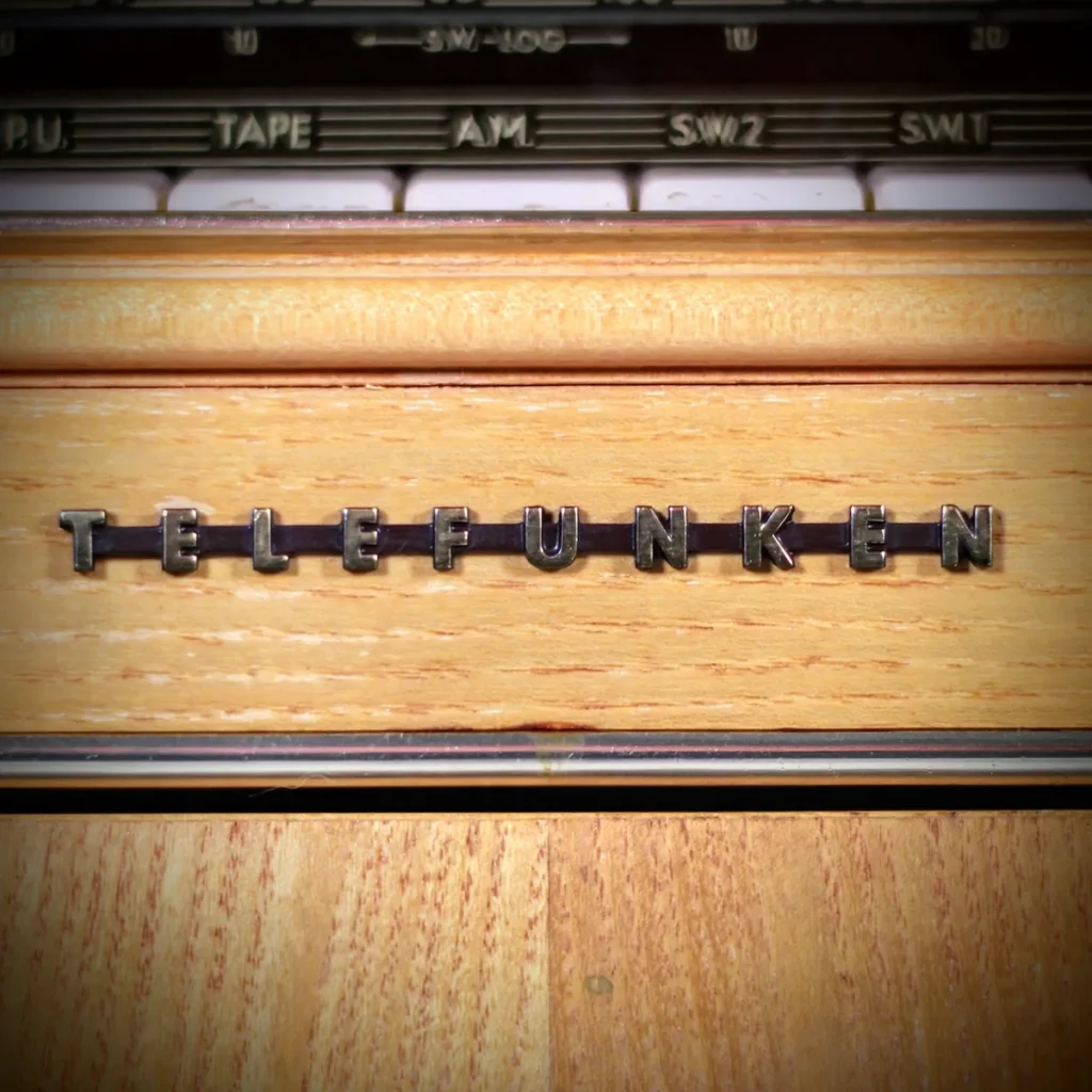 Restored Telefunken metal branding logo on the hand-rubbed wood cabinet.